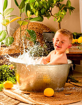 Enfant qui joue dans un bain de lait avec des éclaboussures et des citrons. Joséphine Bot photographe Ariège