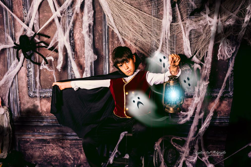 Garçon déguisé avec une lanterne et des fantômes dans une décoration d'Halloween. Joséphine Bot Photographie Ariège