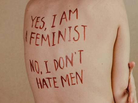Text painted on a person's torso reading 'Yes, I am a feminist, No, I don't hate men' — cover image for Taylor Frankie Paul domestic violence analysis"