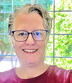 Image of me, Beth Hankoff, owner and teacher for this business. I have light skin and short, wavy, grey hair. I am wearing blue-framed glasses and a red shirt.