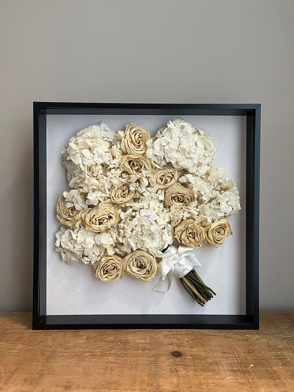 Thumbnail: Preserved wedding bouquet displayed inside a black acrylic shadow box frame