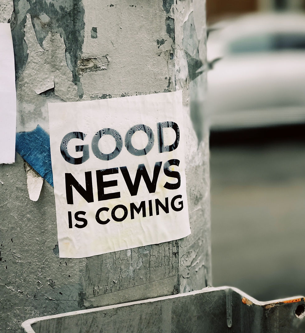 A poster on a pole stating good news is coming