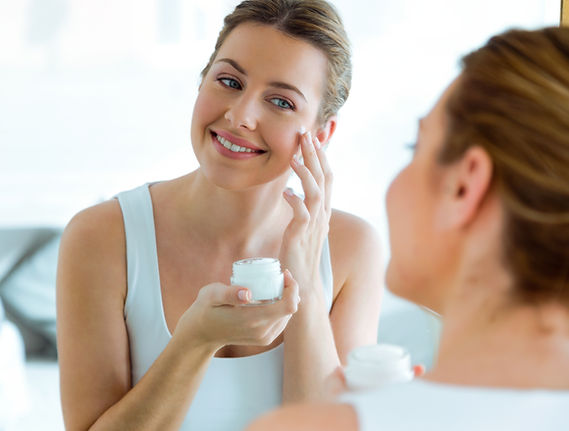 Woman applying anti-aging creams to face
