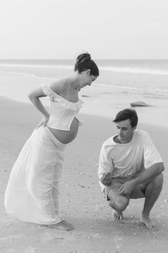 Couple embracing in golden light during luxury fine art maternity session at Washington Oaks