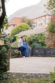 artistic view of couple hanging over terrace gazing at each other Lake Como fine art film and digital wedding photographer