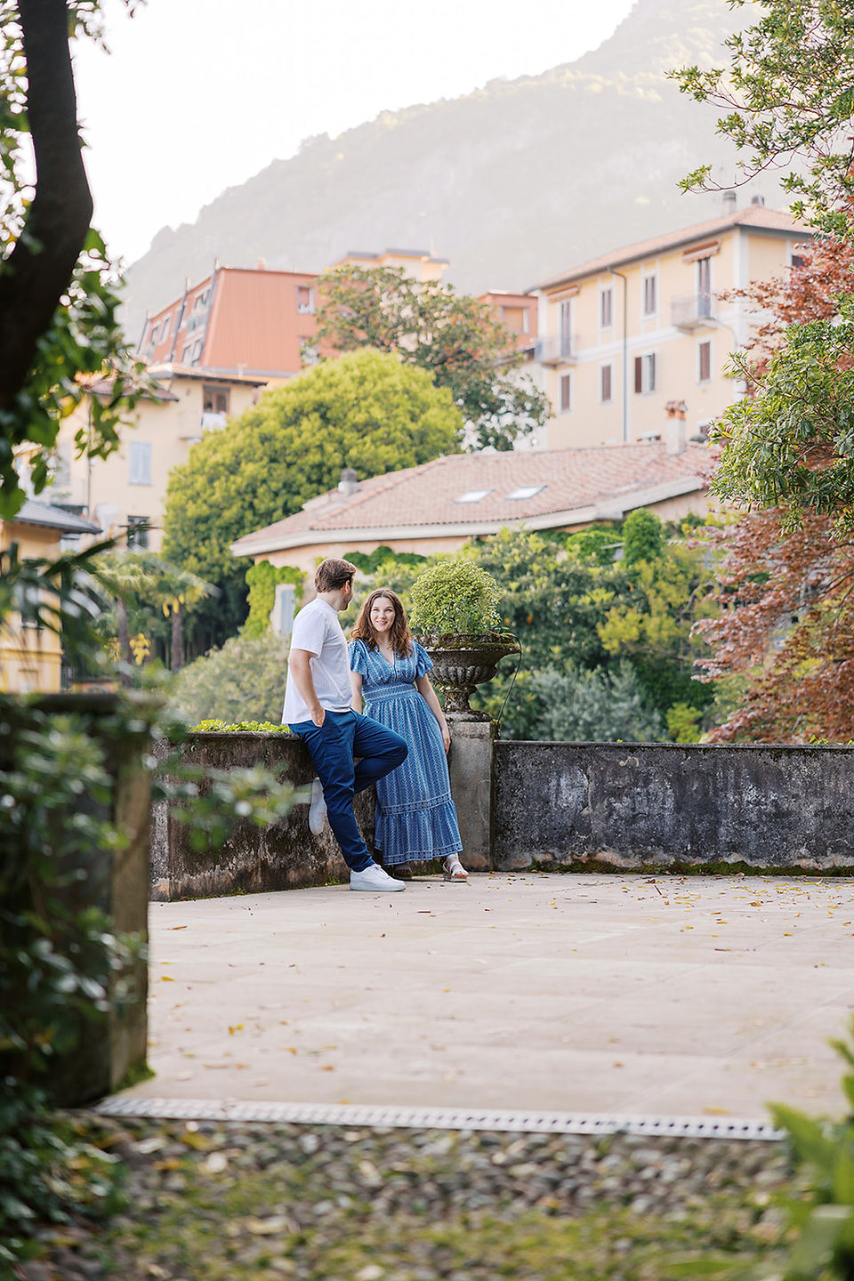 artistic view of couple hanging over terrace gazing at each other Lake Como fine art film and digital wedding photographer