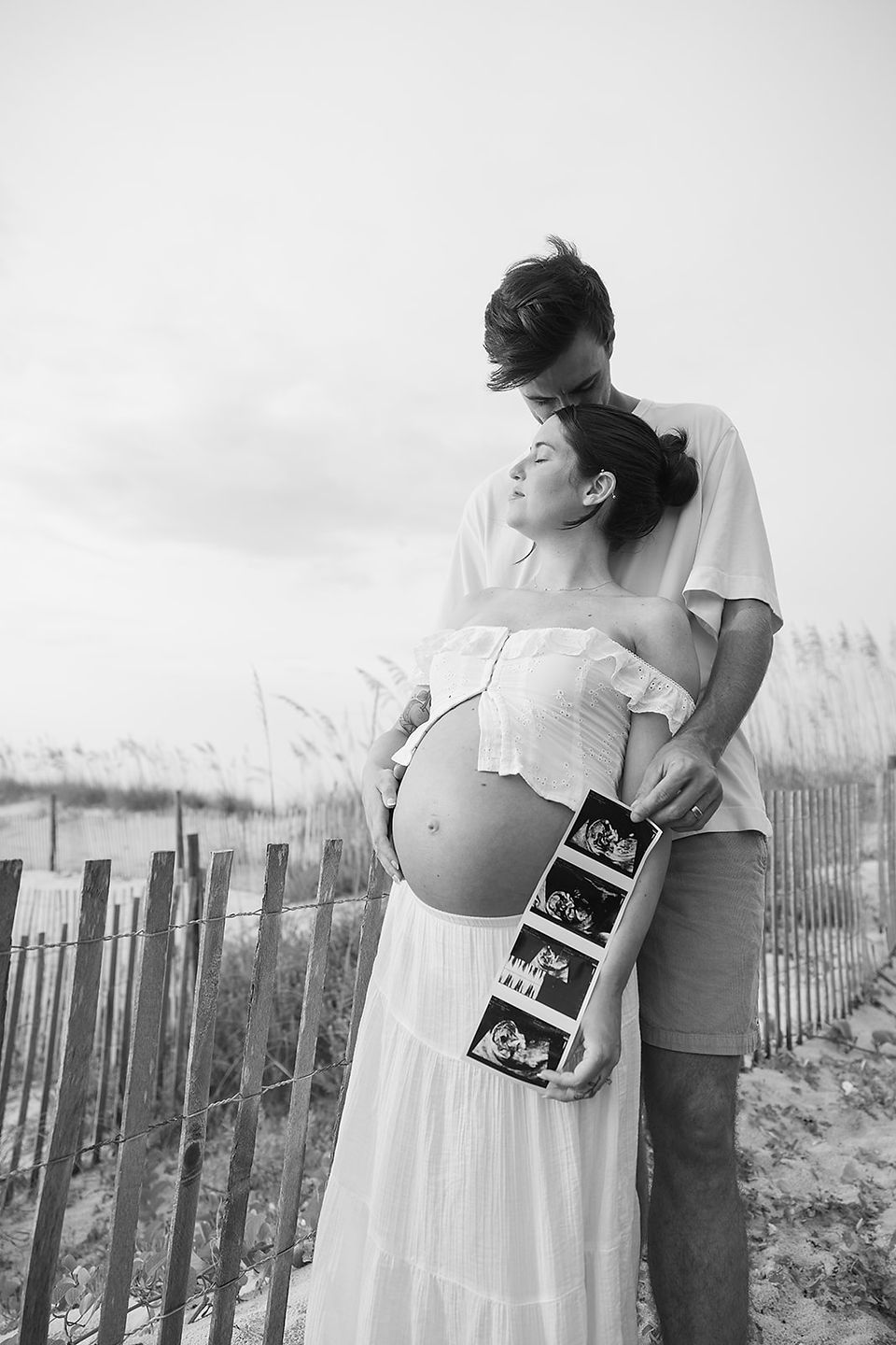 Couple embracing in golden light during luxury fine art maternity session at Washington Oaks