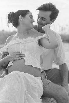 Couple embracing in golden light during luxury fine art maternity session at Washington Oaks