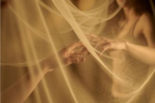 two hands tenderly touching through a veil