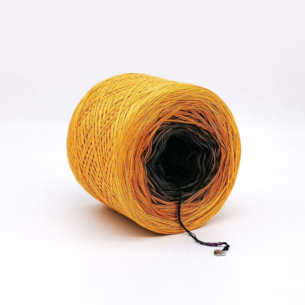 Black, grey, turmeric and mustard yarn cake on a white background