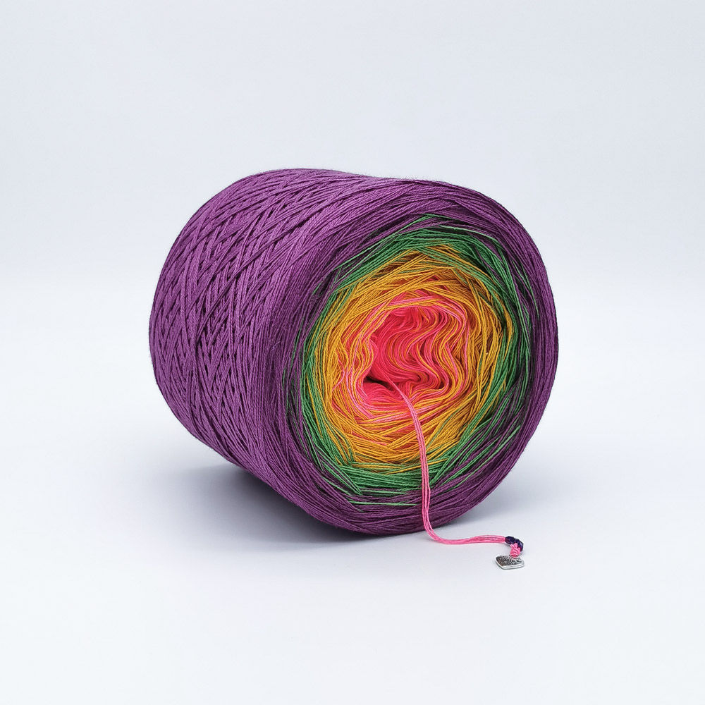 Pink, orange, green and purple yarn cake on a white background