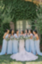 bride and bridesmaids in blue dresses laughing with each other