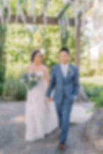 bride looking at groom while walking on paved path
