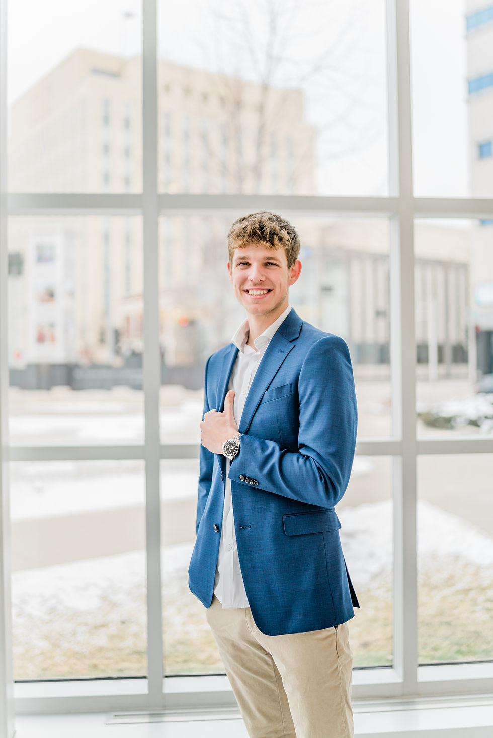 man in blue suit jacket in front of window
