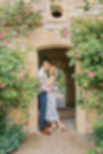 a couple holding each other surrounded by pink flowers