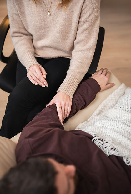 Mann in bequemem Sessel der von einer Frau in Hypnose geführt wird