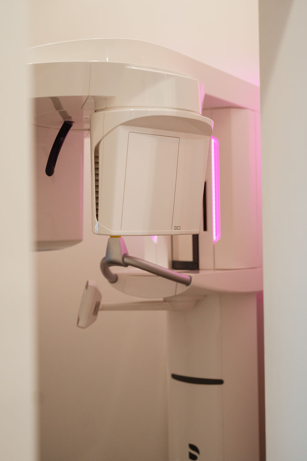 A white 3D dental scanning machine with a pink light.