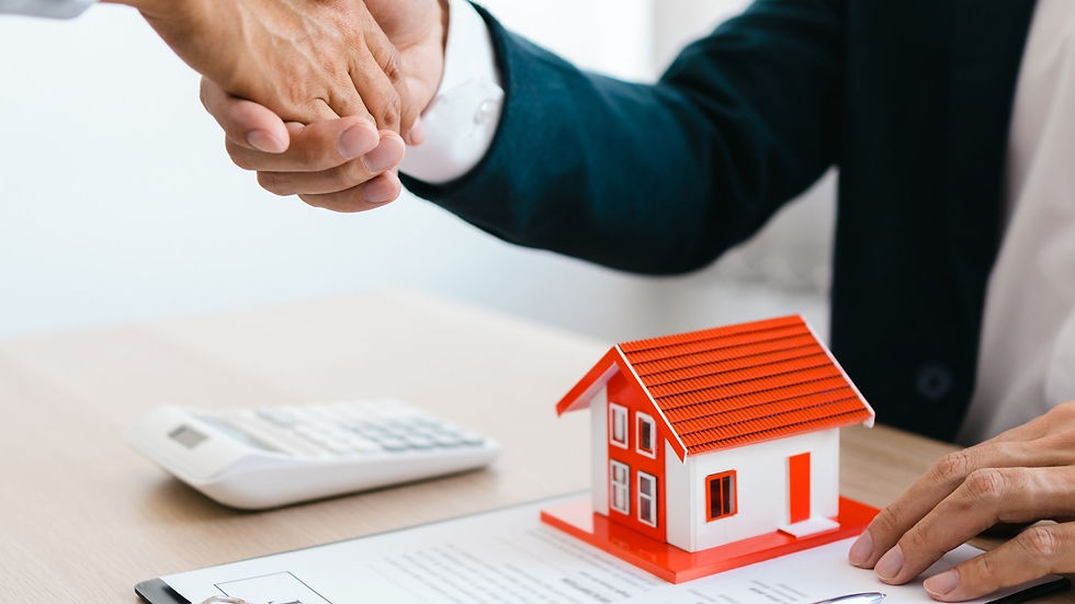 A house model placed on a clipboard and a calculator. Two person's shaking hand.