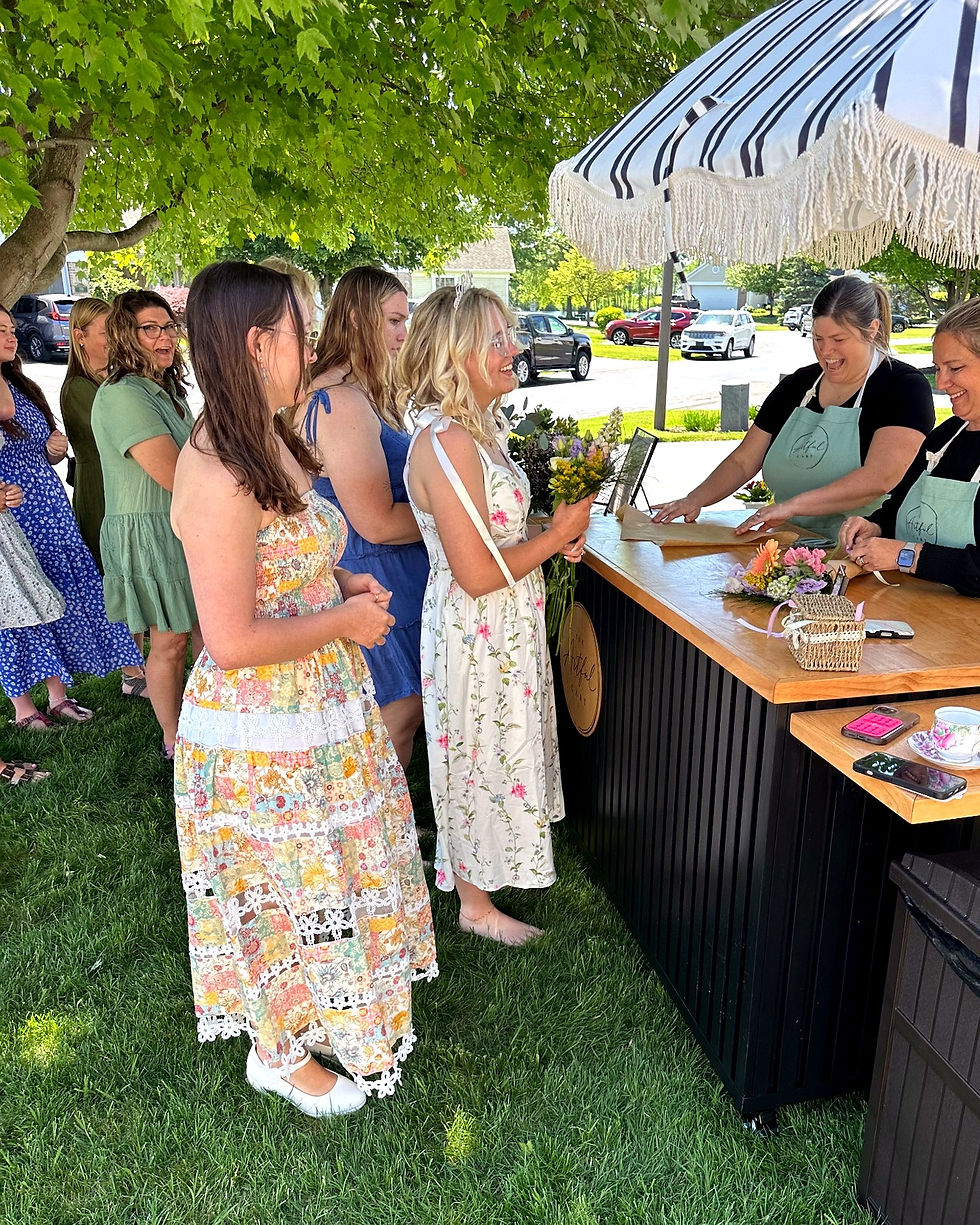 Guests building fresh flower bouquets at The Artful Cart Bloom Bar in West Michigan.