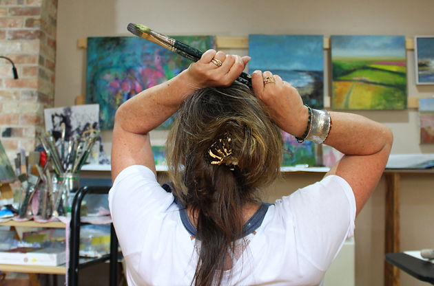 Victoria looking at her coastal paintings.