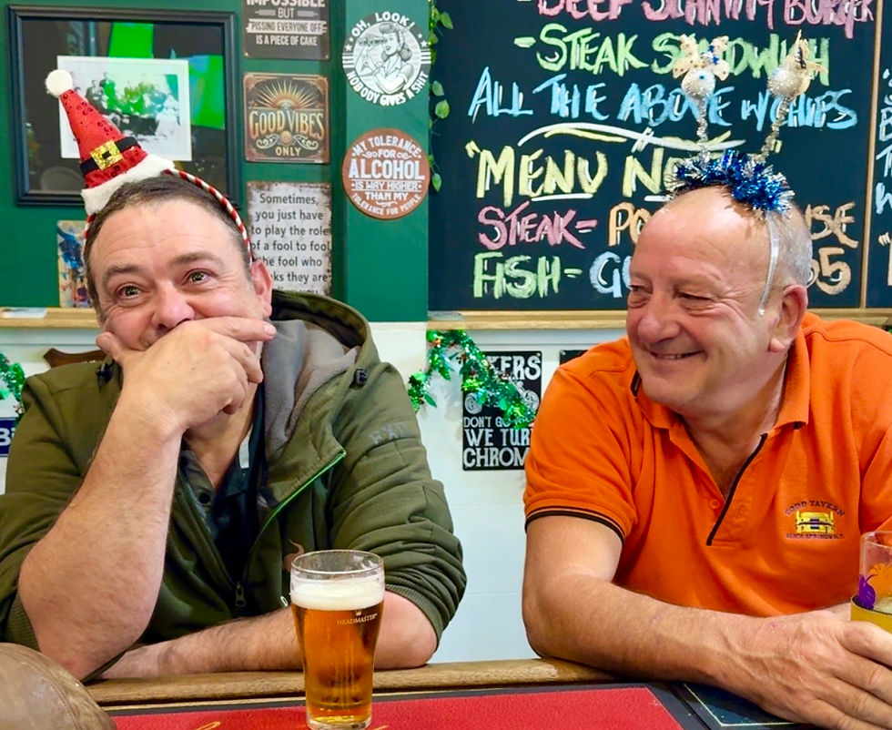 Eye-level view of two locals sitting quietly at a wooden pub table near a window.