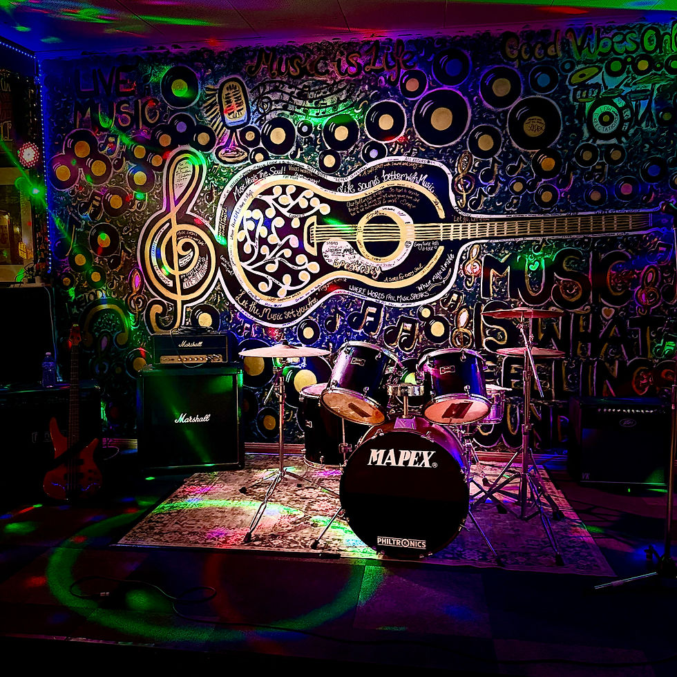 Wide-angle view of a small crowd watching a band under warm stage lights.