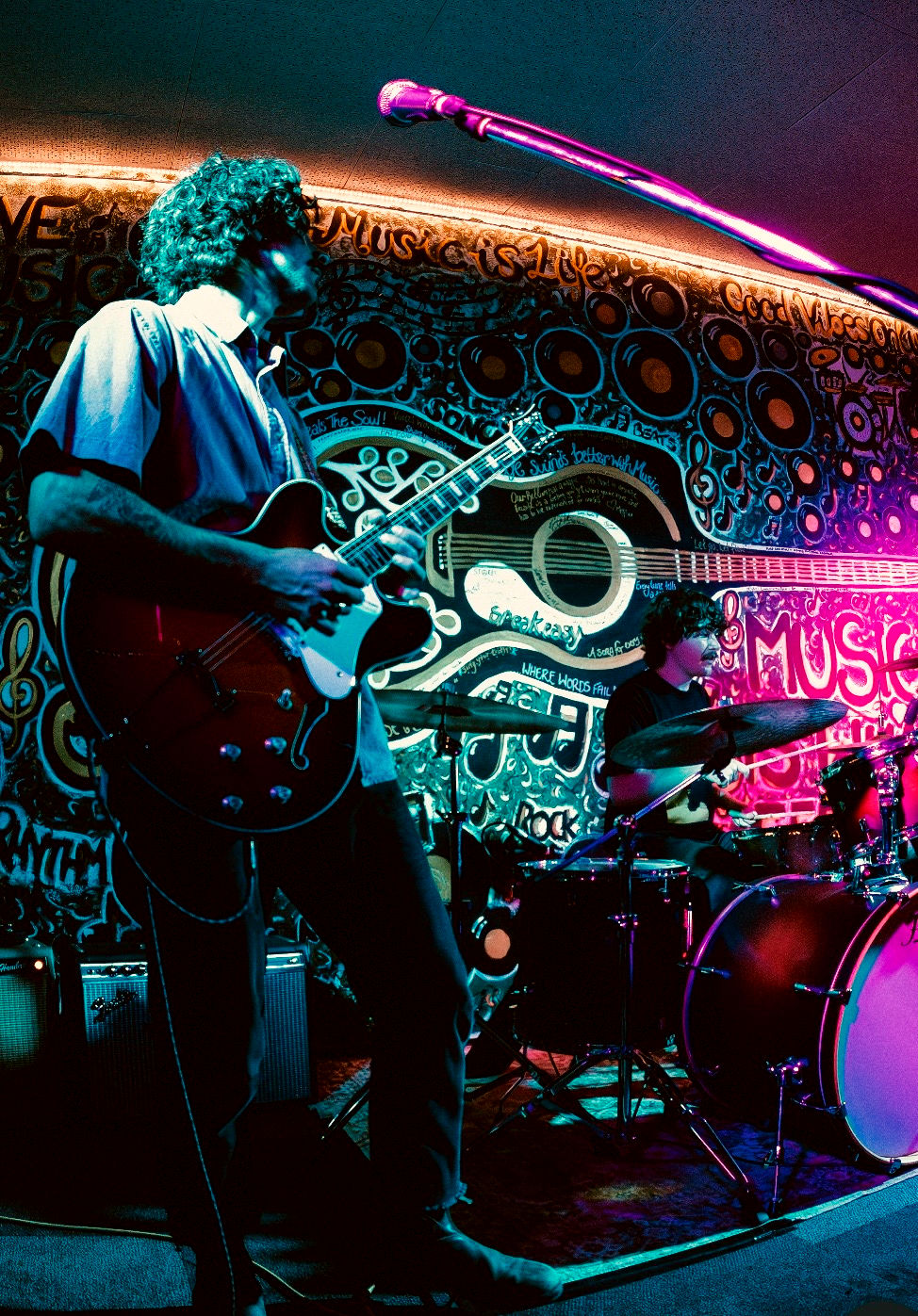 Eye-level view of a young band performing on a small stage in a local venue.