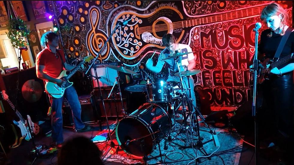 Wide-angle view of an Australian band taking a bow as the crowd cheers in a small venue.