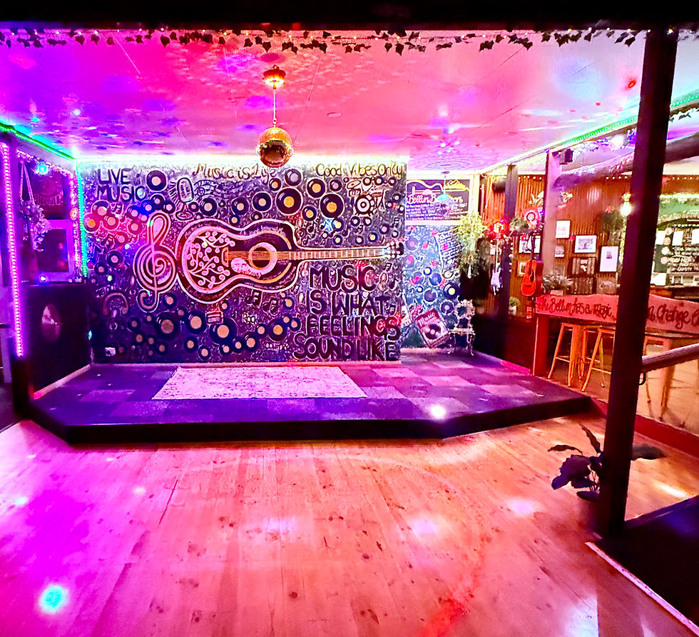 Close-up view of a pub stage with a guitar and microphone ready for a live band