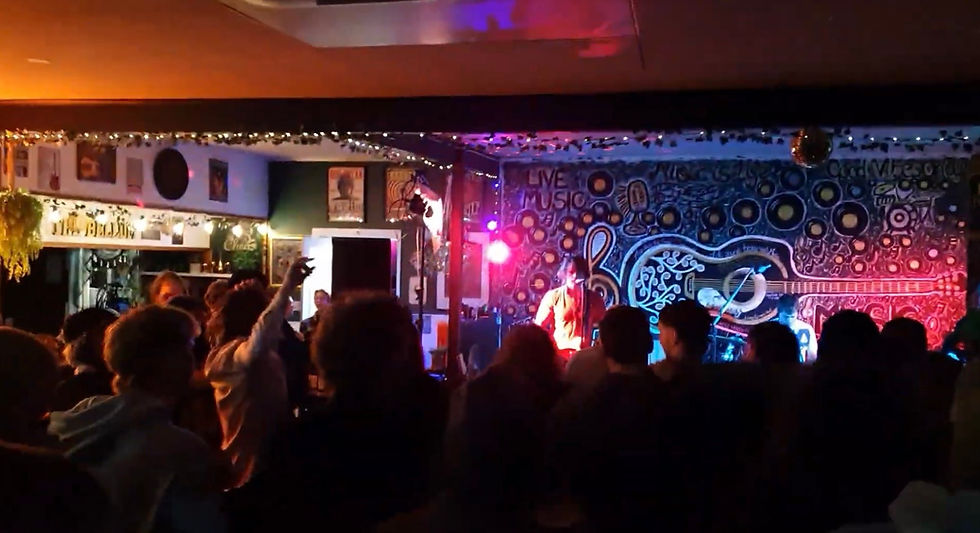 Eye-level view of a rustic country pub with a live band playing on stage