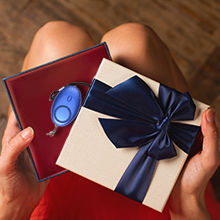 Thumbnail: Woman opening gifts, a blue gift and a cream box with dark blue ribbon.