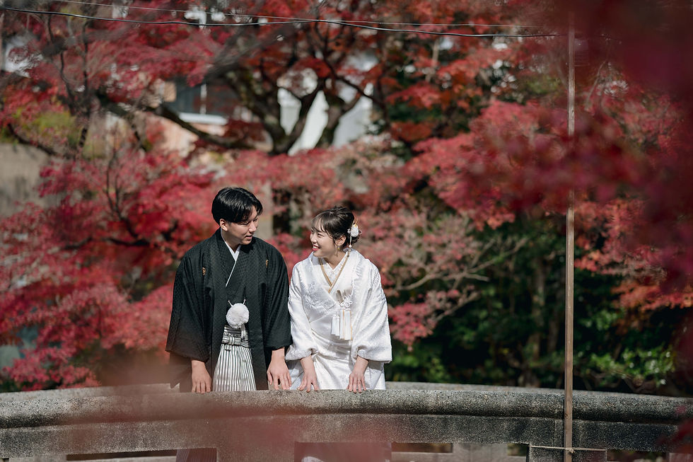 秋の神前挙式。紅葉の中で撮影する新郎新婦の様子。