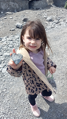  A happy, young girl showing a heart-shaped fossil she found in the Fossil Park.