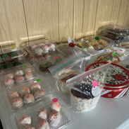 Assorted Christmas cookies and pastries in clear containers displayed on a table during the Sacred Heart of Jesus PNCC holiday bake sale.