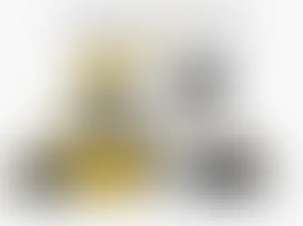 Technician working on heavy equipment in a service bay checking a text message on his phone.