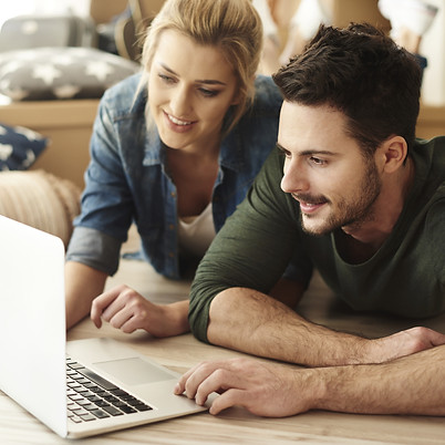 pareja sonriendo con portatil