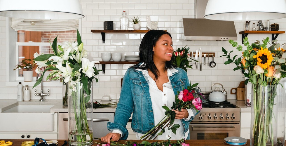 Naia Geni Interior Florist arranging flowers in kitchen at home studio as a floral designer