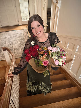 Megan on staircase holding flowers smiling_edited.jpg