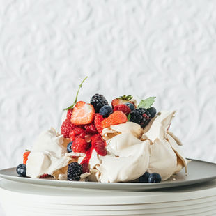 Cinamonu, imbieru ir aviečių bei juodųjų serbentų padažu skaninta „Pavlova“