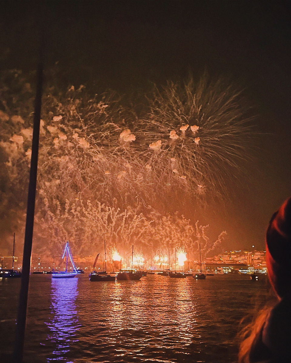 Fireworks display over Lisbon’s Tagus River seen from a boat.