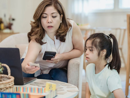 Mother helping her daughter ask for what she wants using picture cards