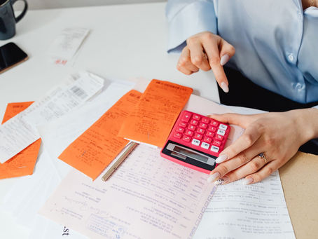 Hands with a calculator and receipts, working out early intervention costs
