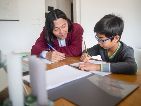 Therapist working one to one with a child at the table at home