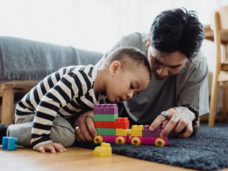 Father and son playing with colourful blocks at home