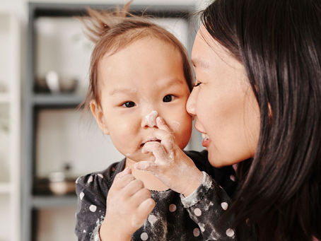 Mother and toddler baking together in the kitchen, talking as they go