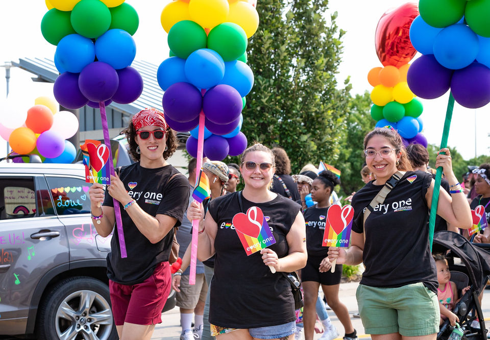 Signature Performance team members at the Heartland Pride Parade with rainbow balloons
