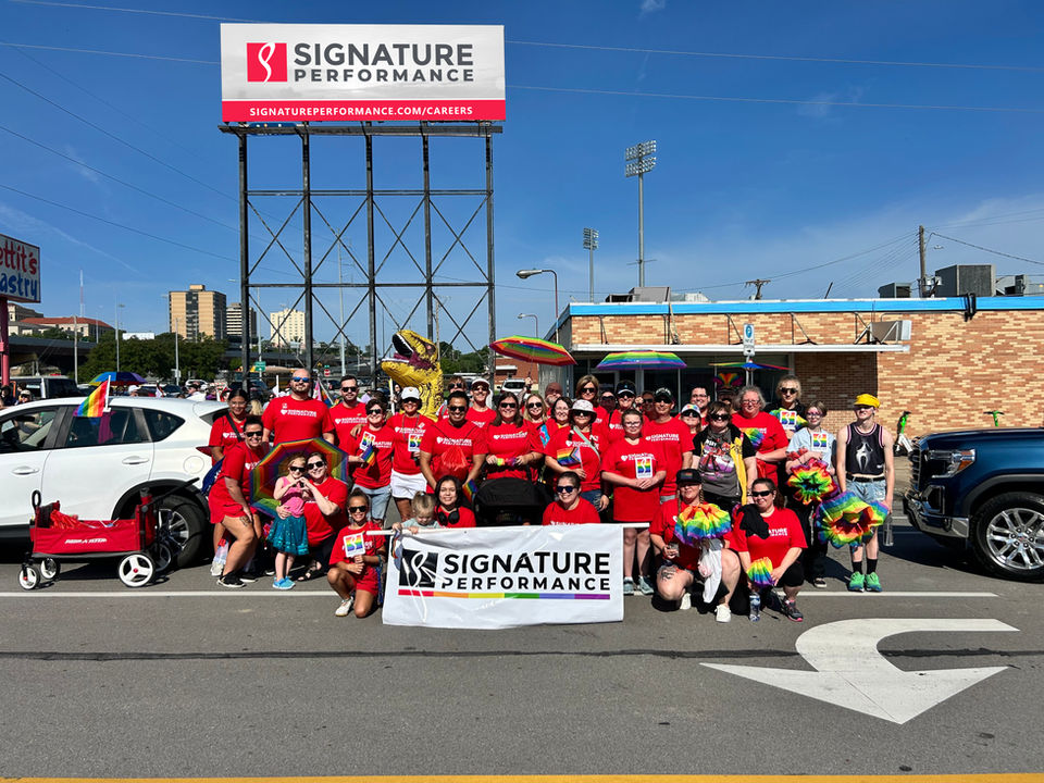 Signature Performance team at the Heartland Pride Parade with company banner