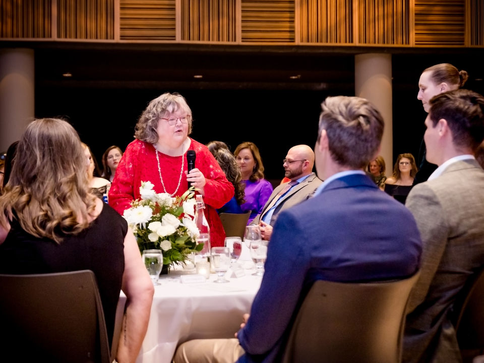 Signature Performance team member speaking at a formal company event