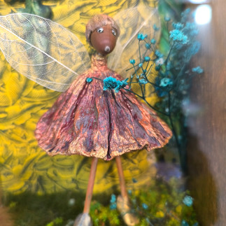 La fée de l'Automne en robe mauve debout parmi des paillettes