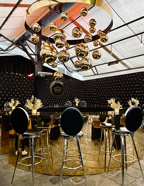 Luxurious Moët & Chandon Christmas setup with golden bar, festive string lights, and elegant black-and-gold holiday decor